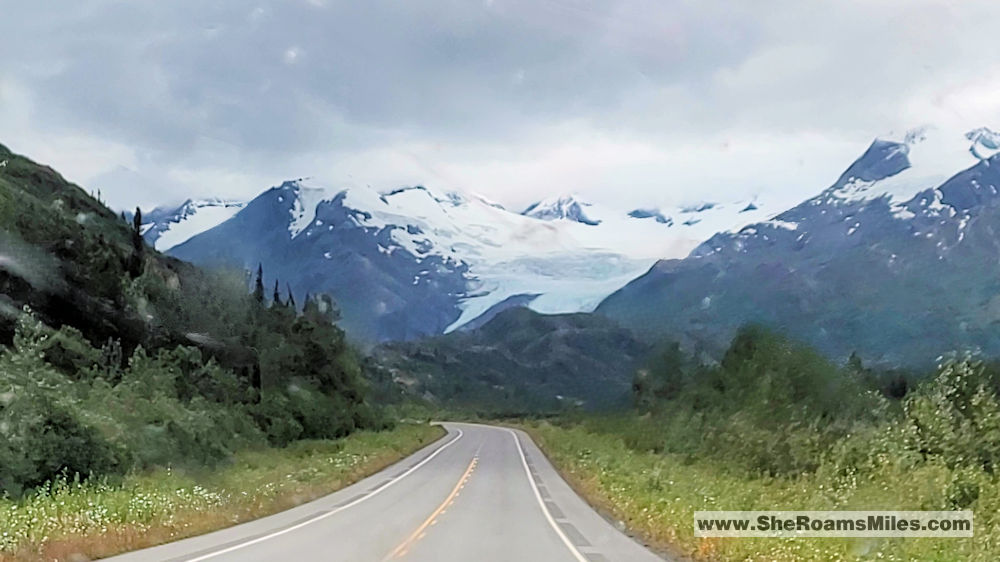 A Road With Snow Covered Mountains In The Background